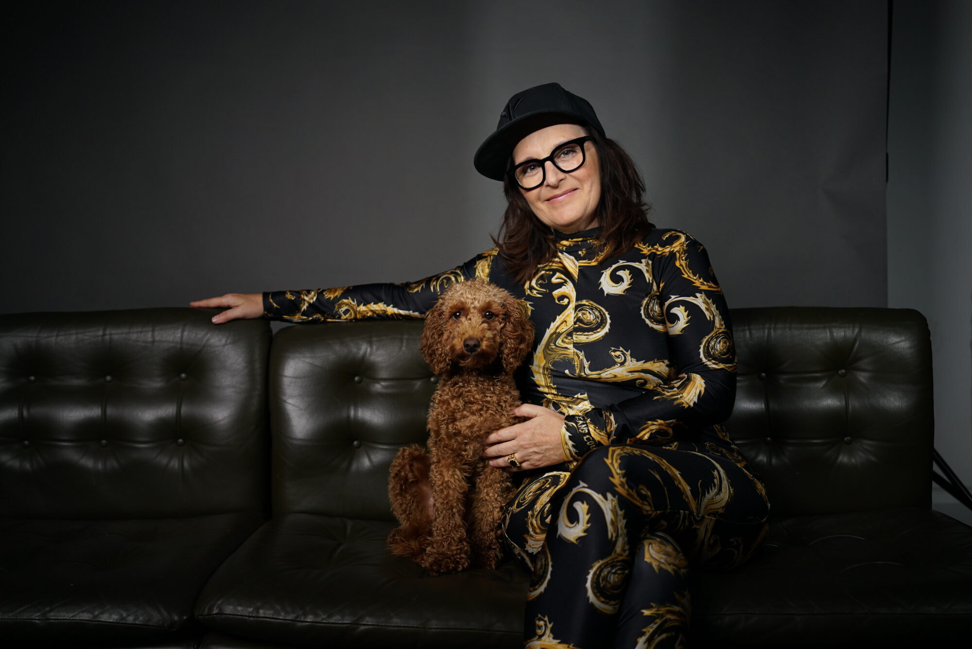 Anja Maria Welzel sitzt mit ihrem Hund auf einem Sofa.